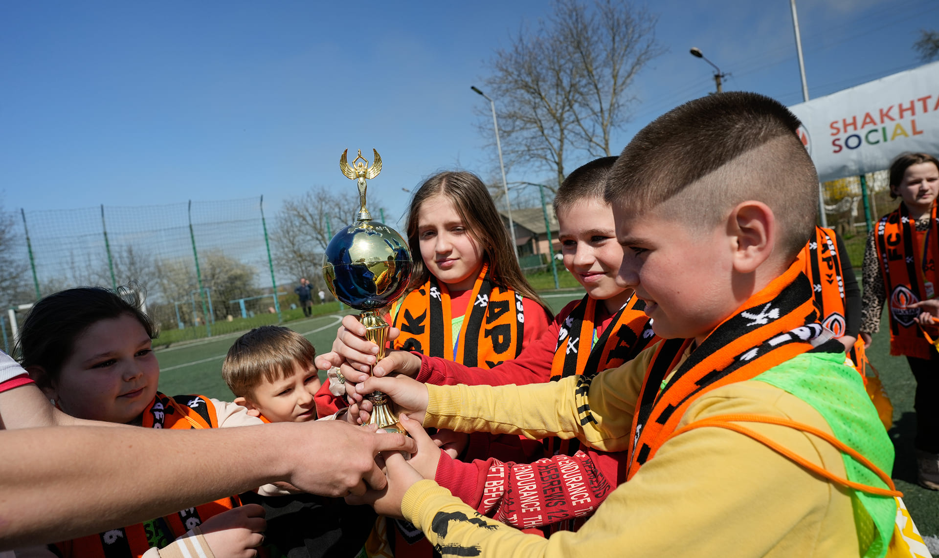 Children playing football on a DTEK-supported pitch in Ukraine, promoting youth sports and inclusion